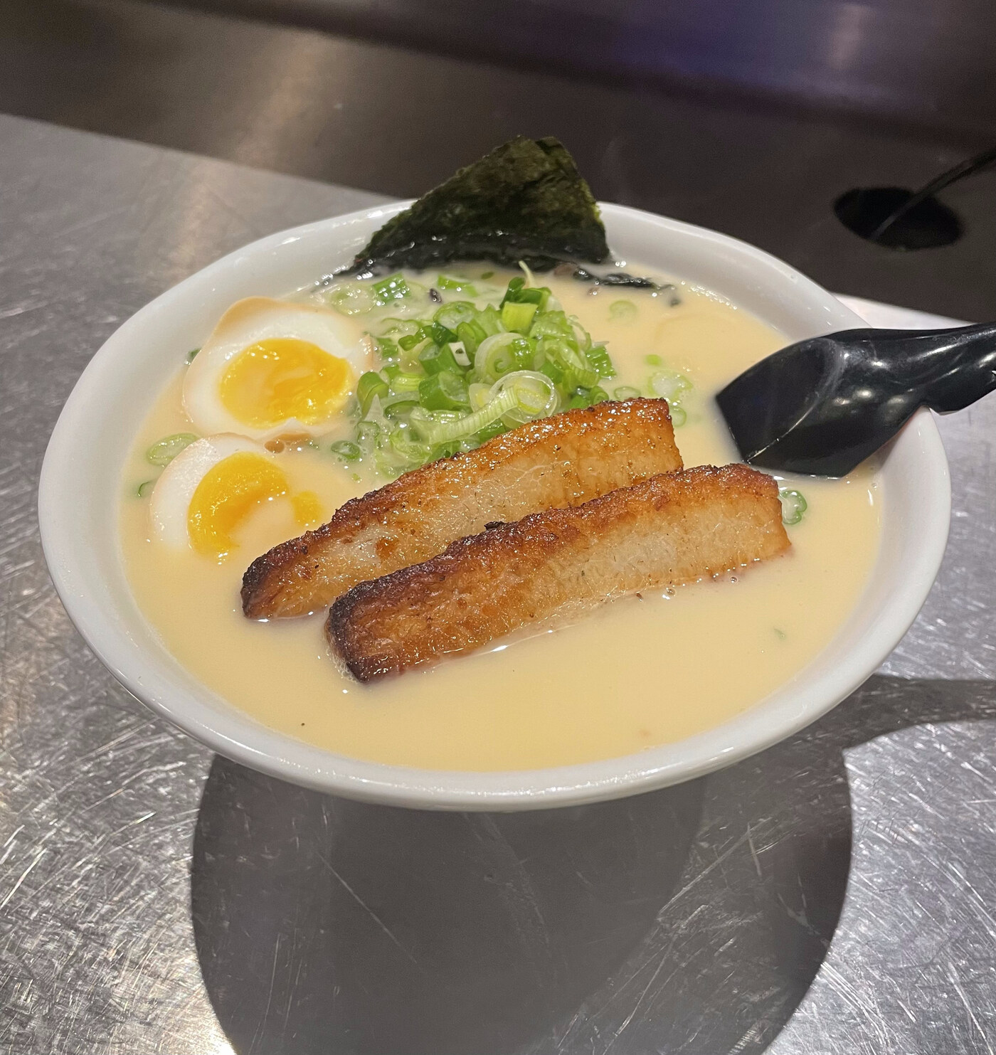 Nikka Ramen's milky Tonkotsu broth bowl with seared pork belly chashu, soft-boiled egg, green onion, and nori